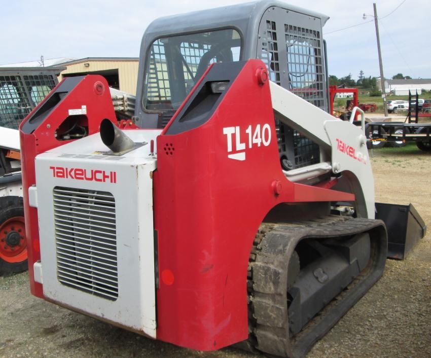 A red and white takeuchi tl140 skid steer