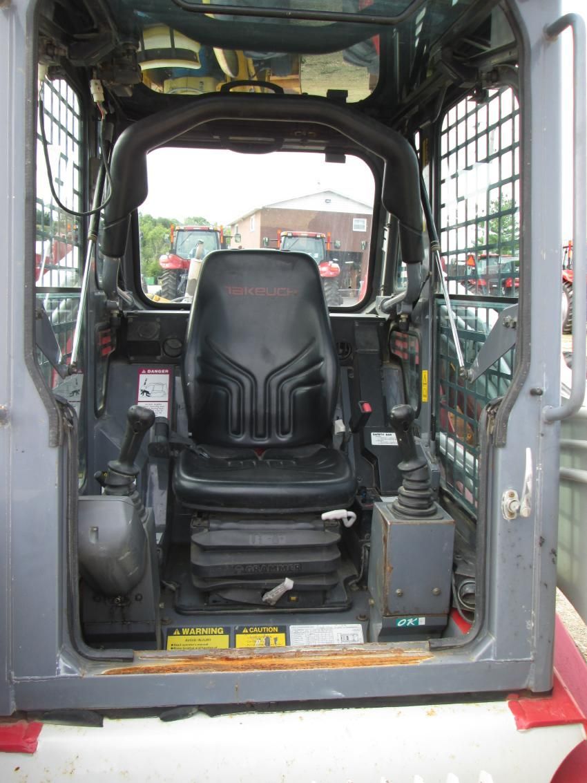 The inside of a bulldozer with a black seat