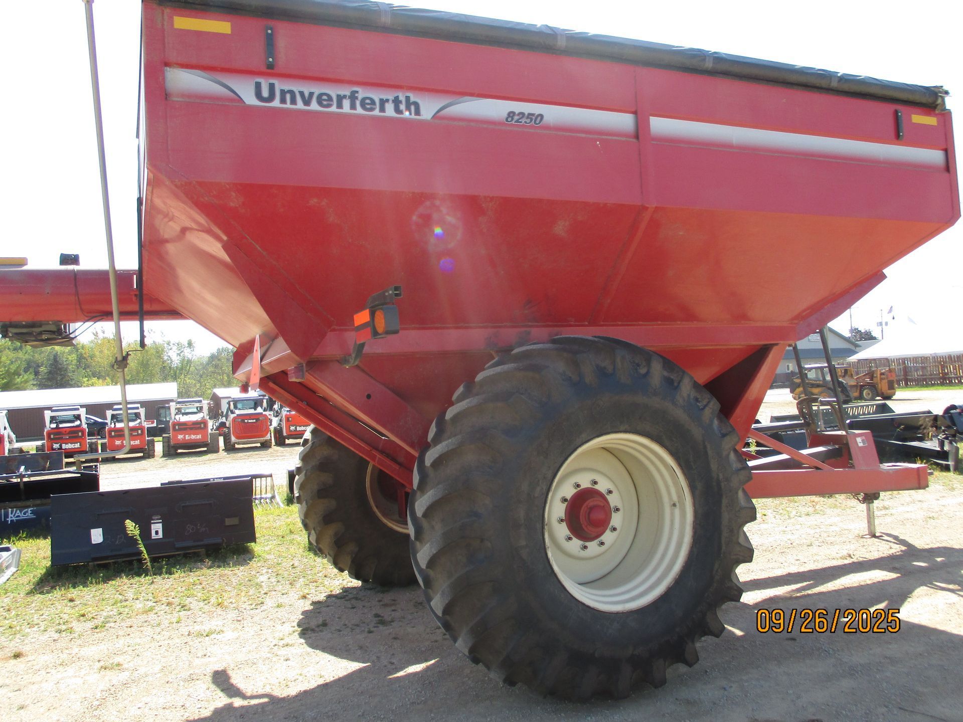 Red Unverferth grain cart with large tires, sitting outside.