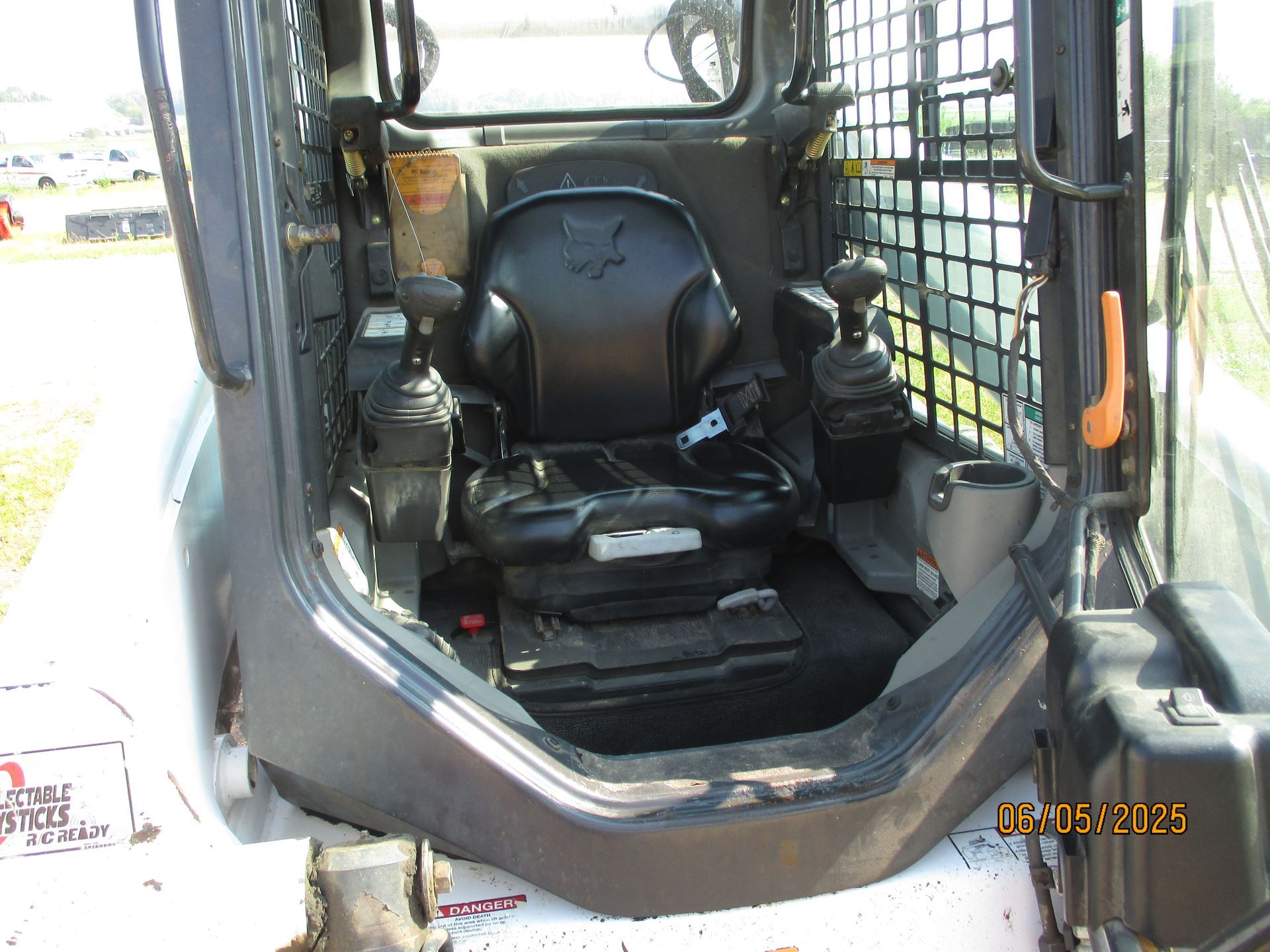 The inside of a bobcat skid steer with a black seat