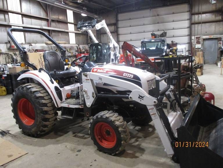 A bobcat tractor is parked in a garage.