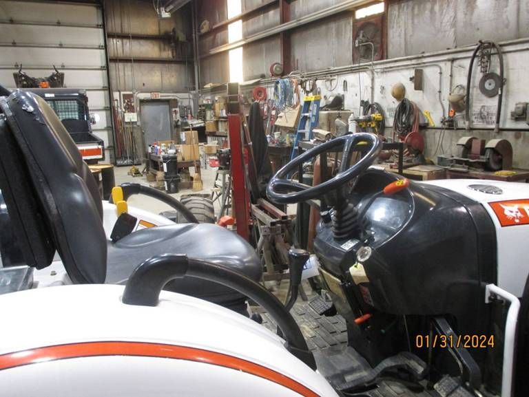 A white tractor is parked in a garage on january 31 2024