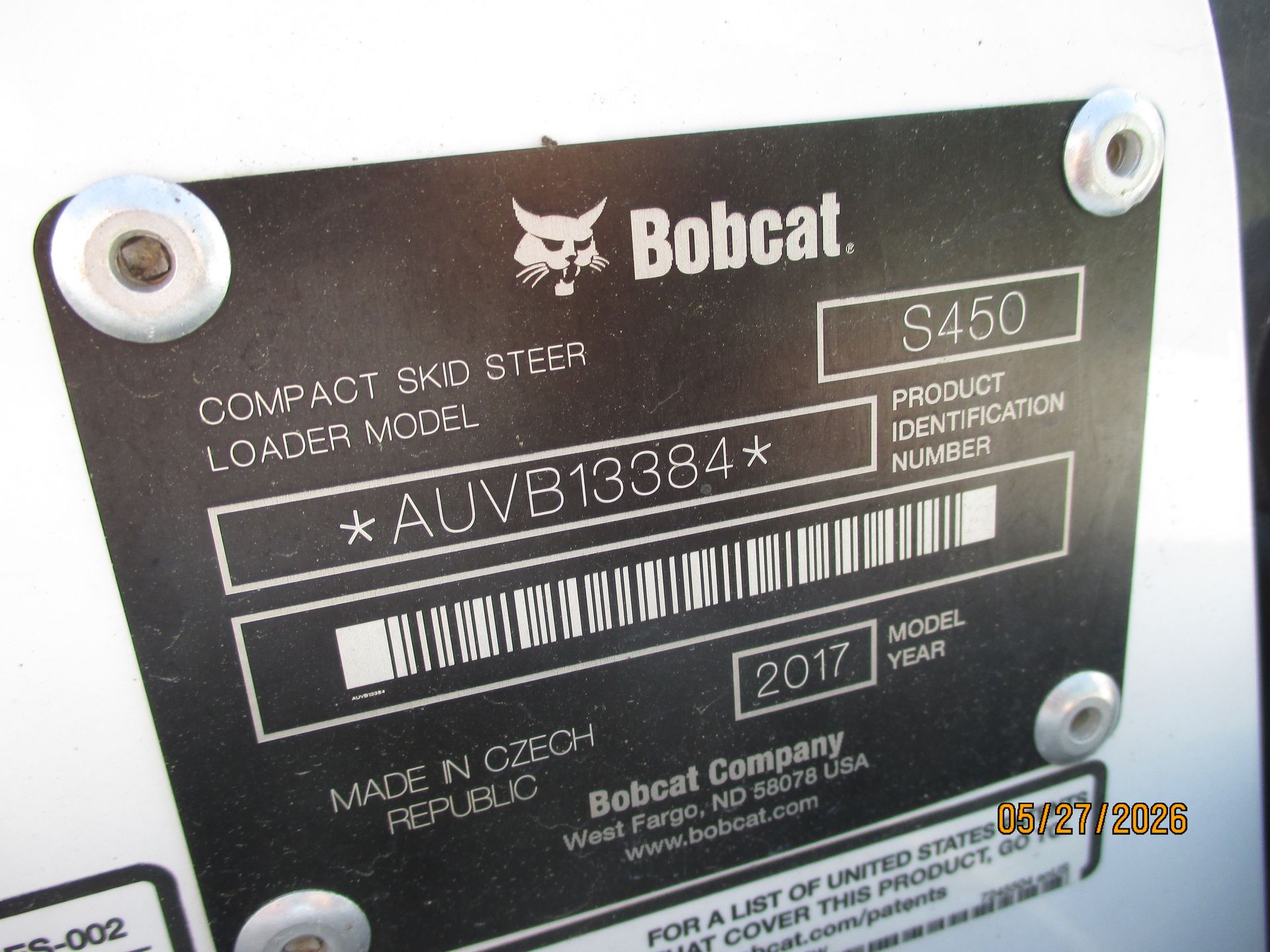 Close-up of a Bobcat machine identification plate with model and serial number details.