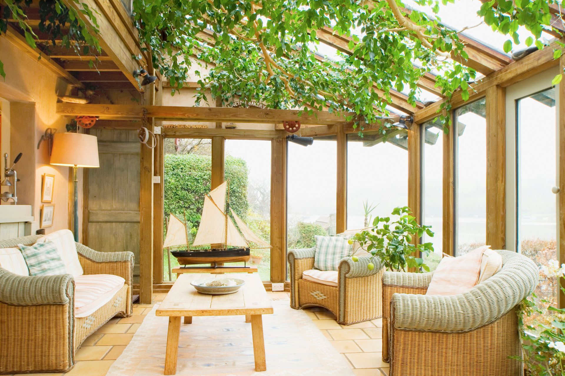A sun room with wooden framing and plants hanging