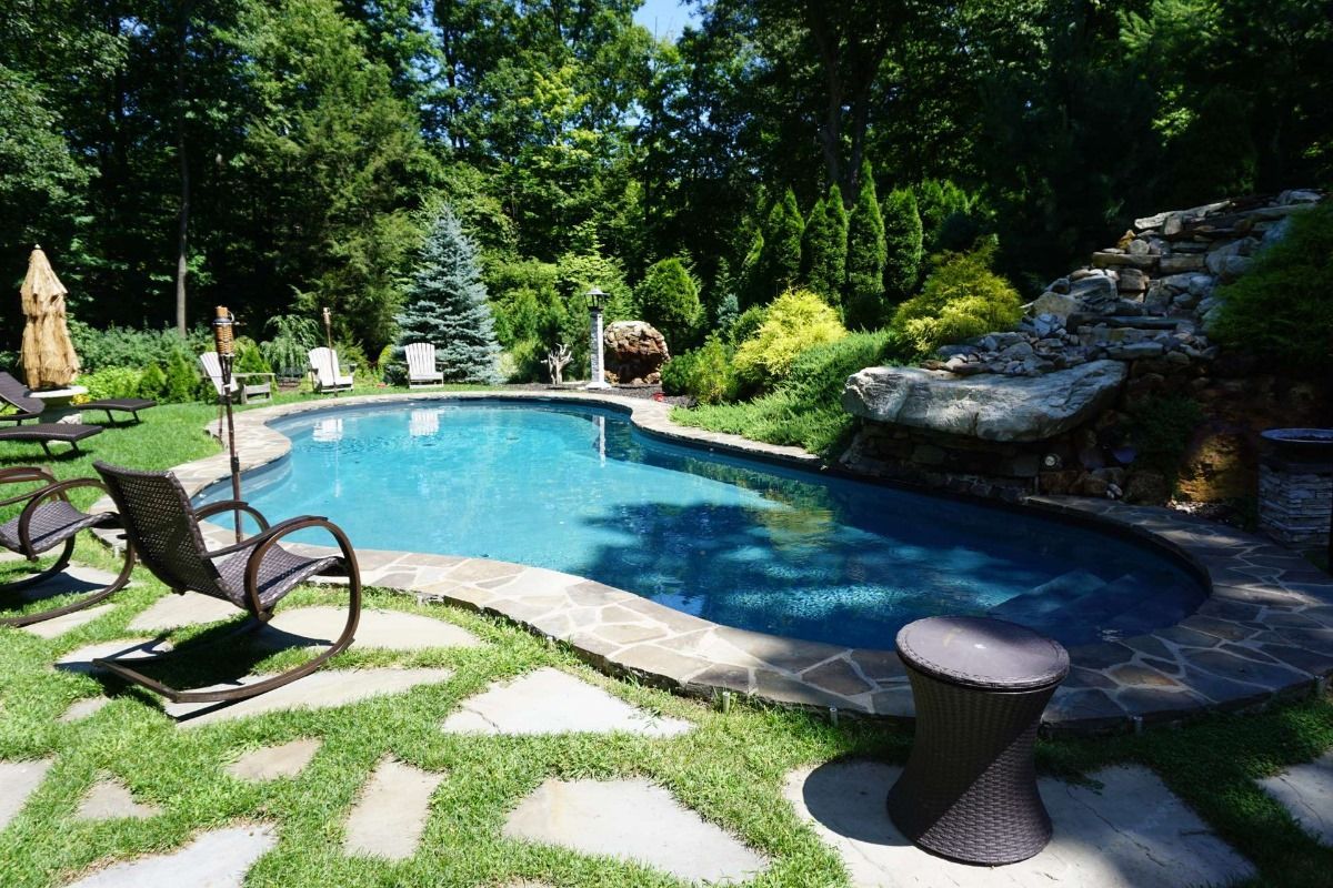 There is a large swimming pool in the middle of the backyard