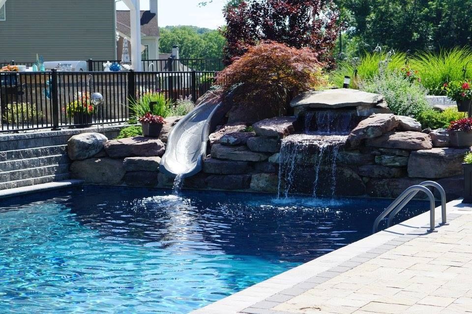 A swimming pool with a water slide and a waterfall