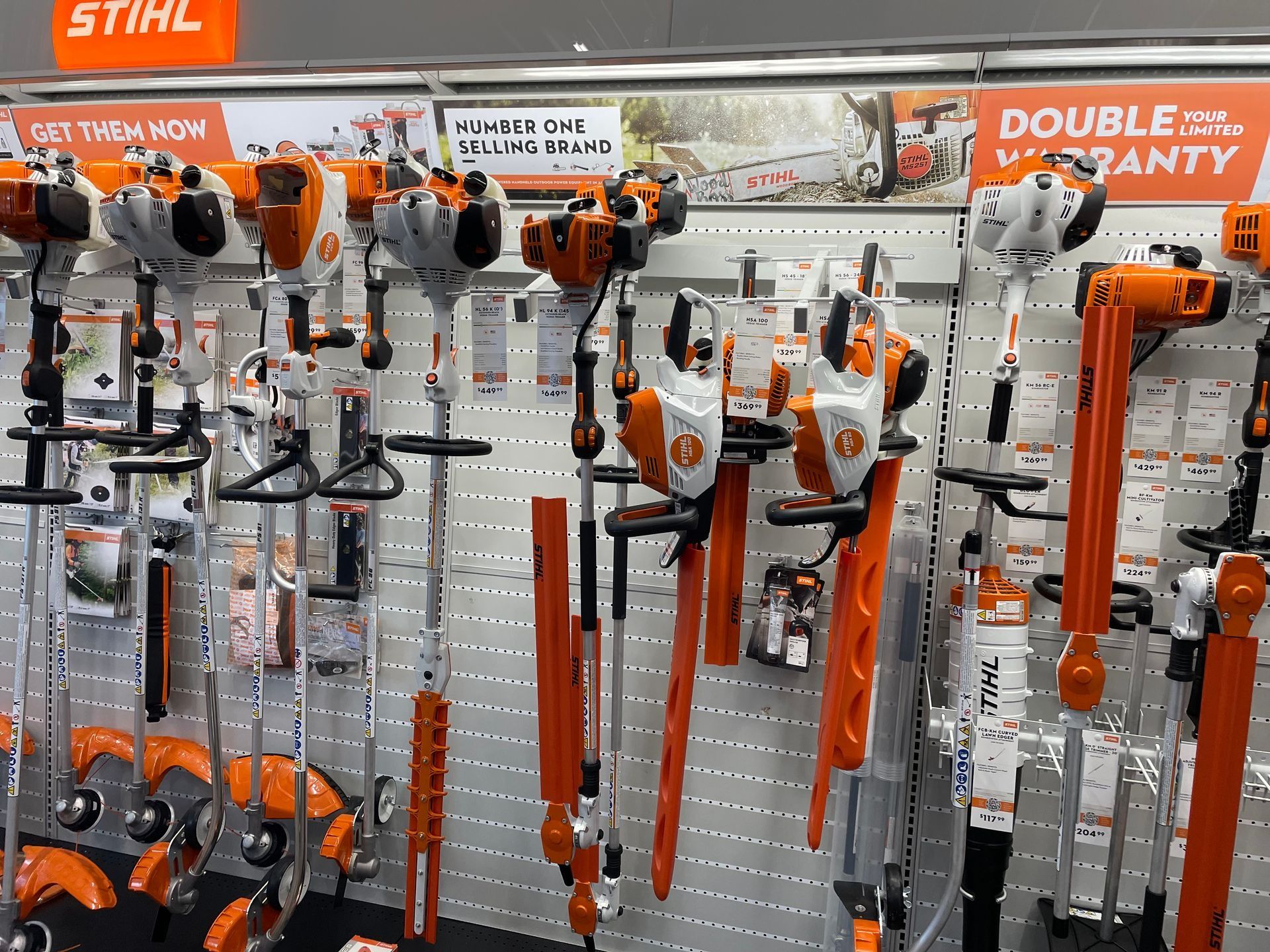 Stihl brand landscaping tools displayed on a store shelf orange and white color scheme.