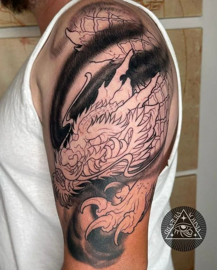Line art dragon tattoo on a person's upper arm, with shaded background.