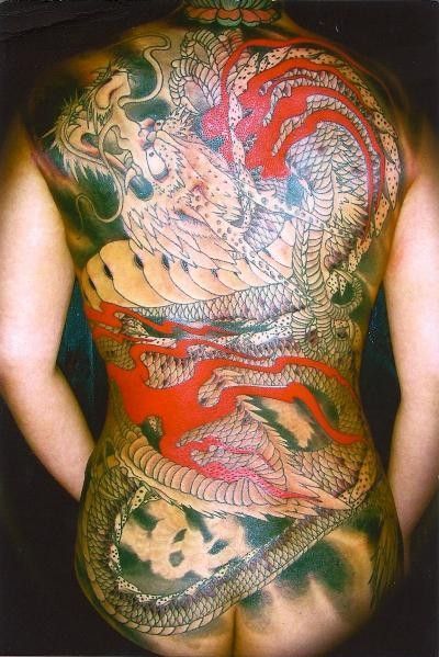 Back tattoo of a large, red and white dragon on a person's back, wrapping around the torso.