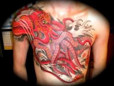 Red octopus tattoo on a person's torso, with tentacles and Japanese wave details.