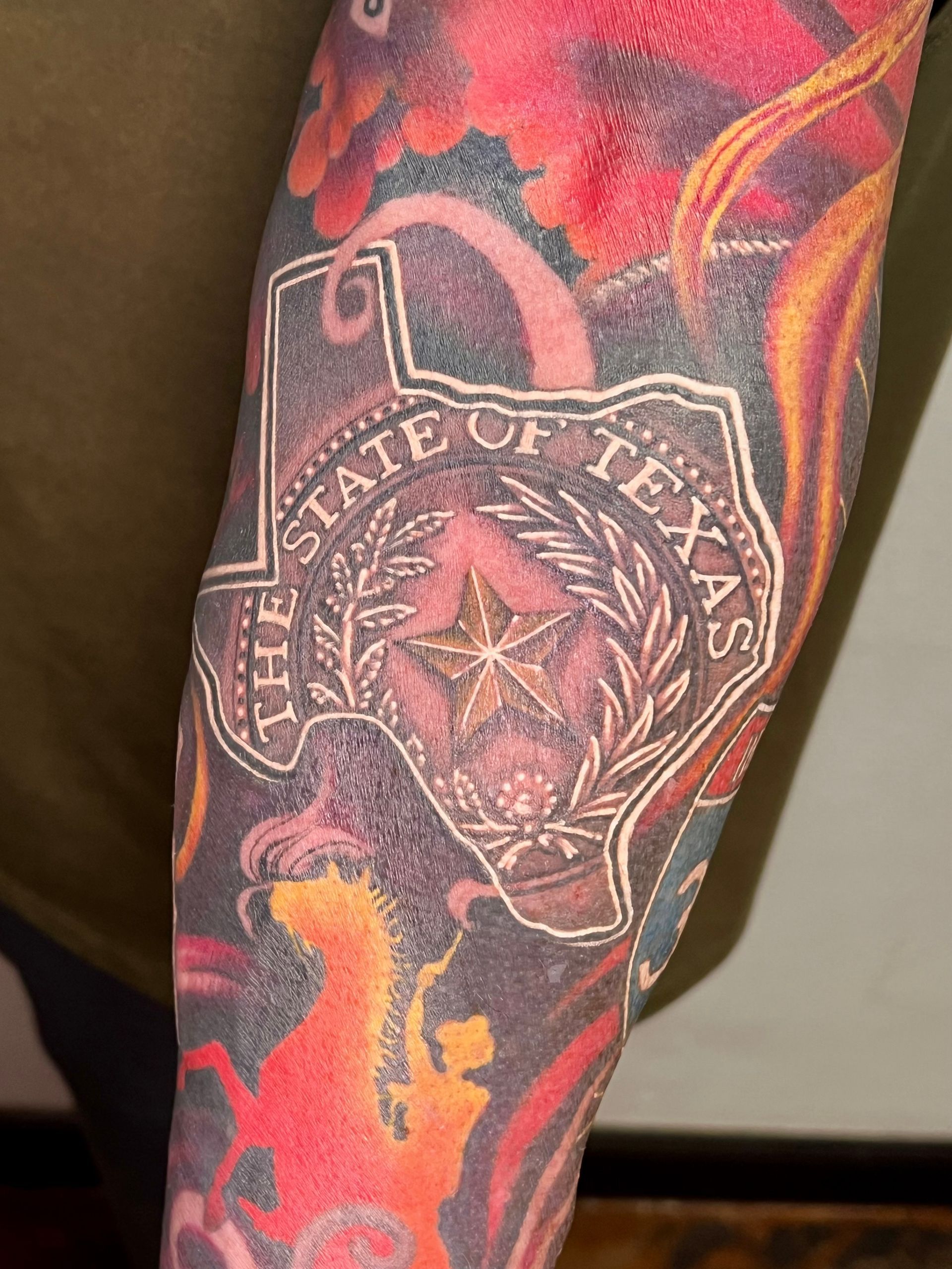 A tattoo depicting a Texas seal emerging from the outline of the state of Texas