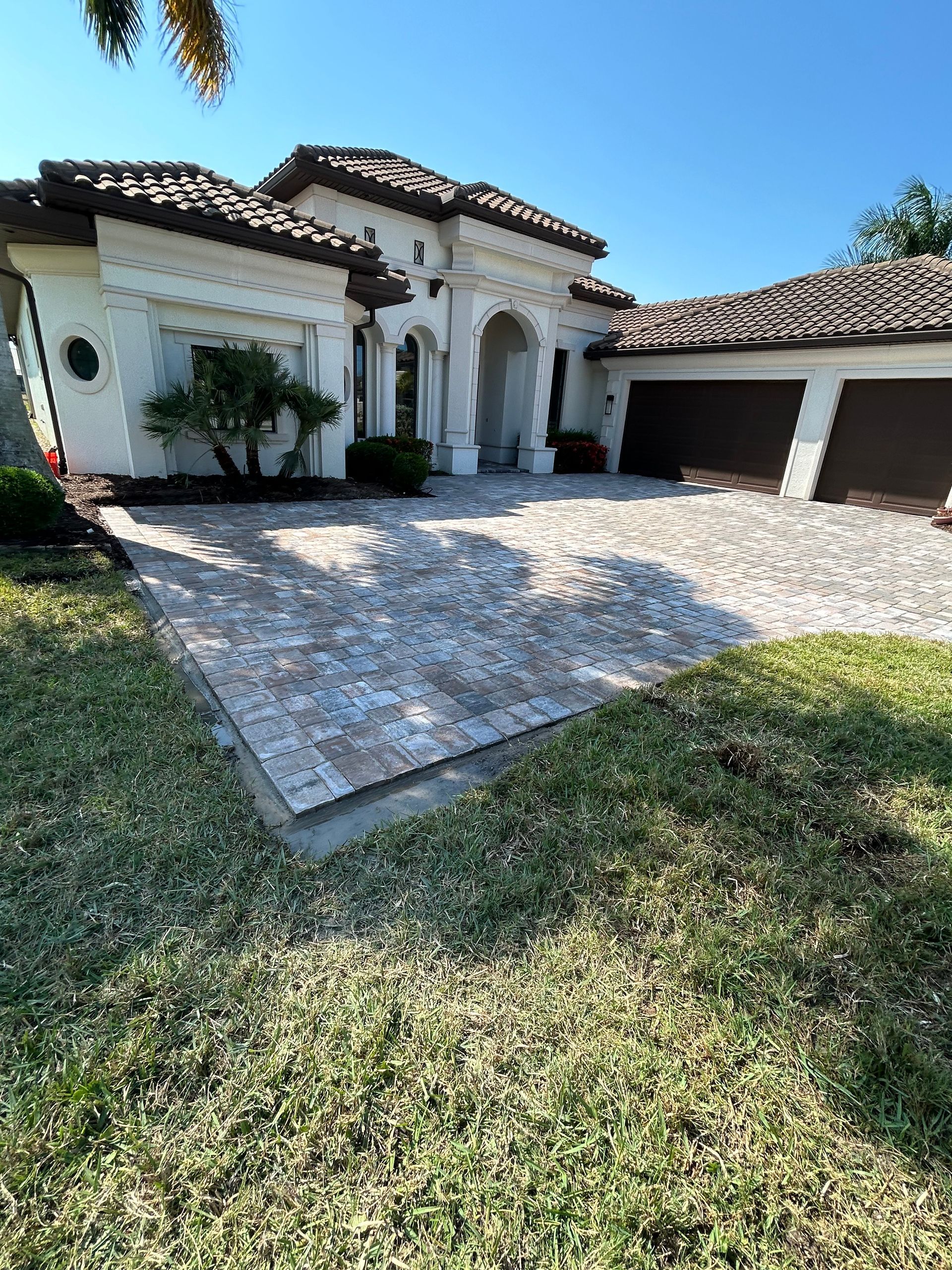 A large white house with a driveway in front of it.