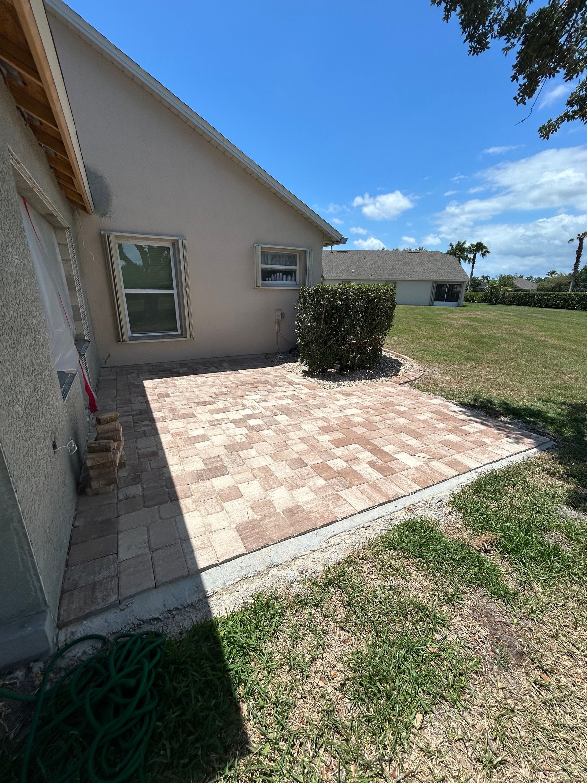 There is a patio in the backyard of a house.