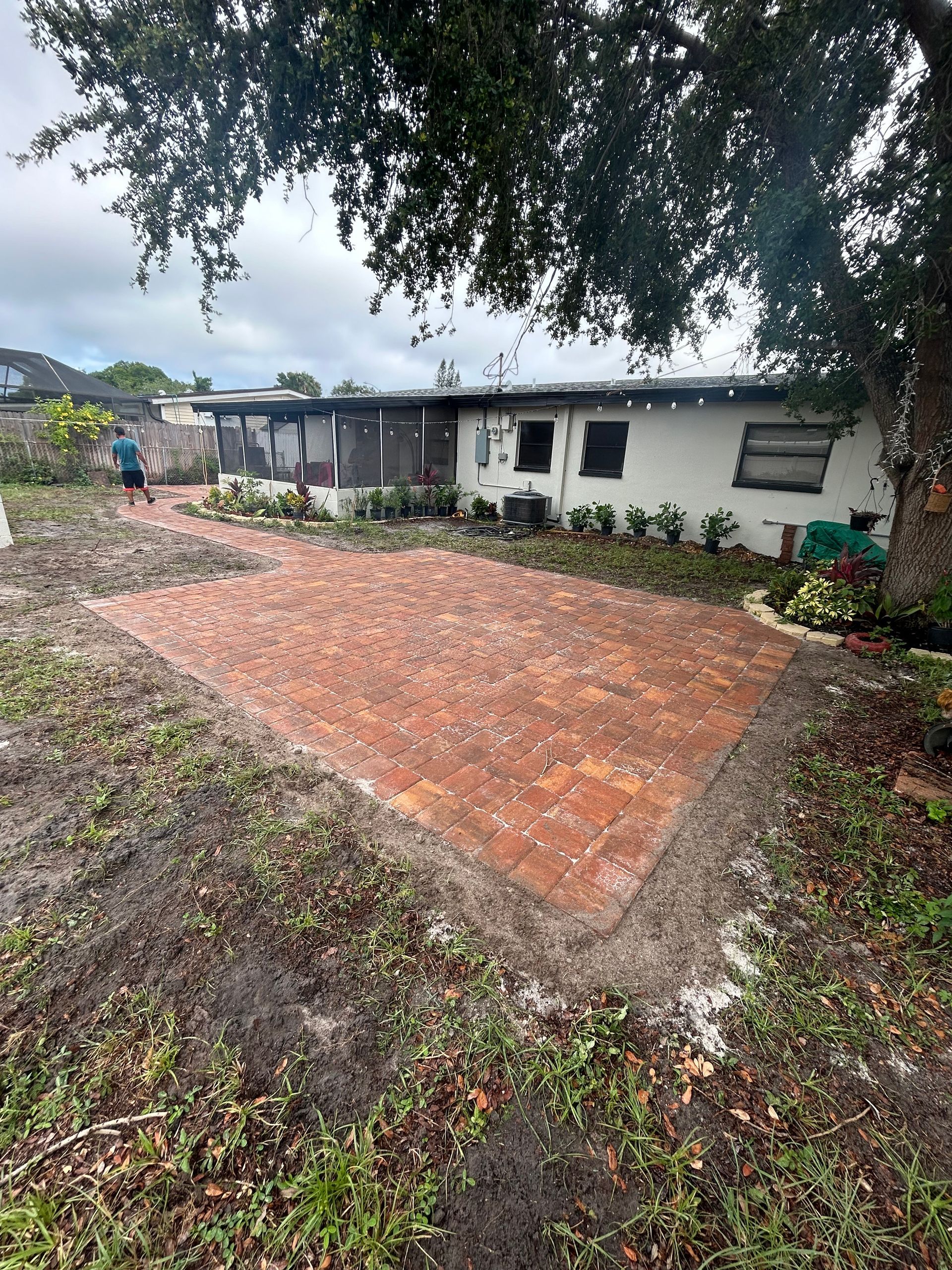 A white house with a brick driveway in front of it.