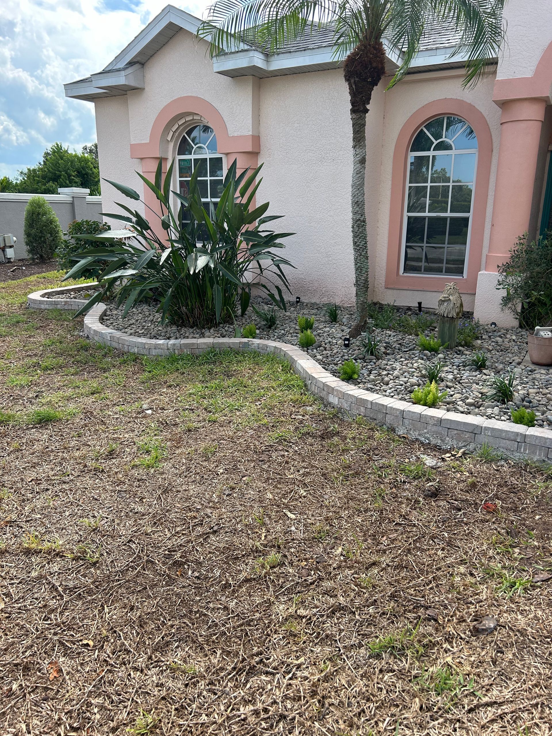 A house with a lot of plants in front of it.