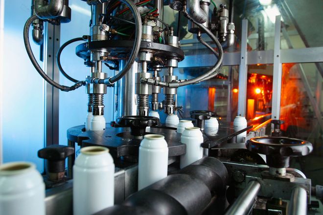 Automated bottling line filling white plastic bottles in an industrial factory