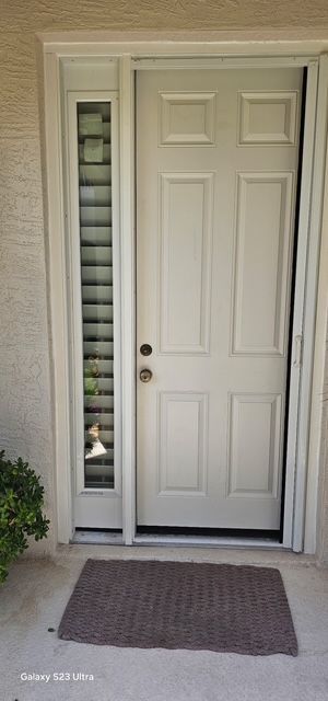 Front entry door with glass sidelight and dark doormat