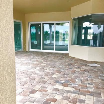 Covered patio with tiled floor and sliding glass doors leading into a home