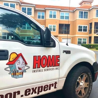 White Home Install Services truck with logo and website text on the side, parked outdoors.