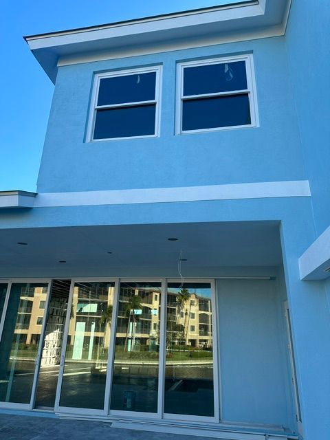 Modern blue building exterior with large windows and sliding glass doors