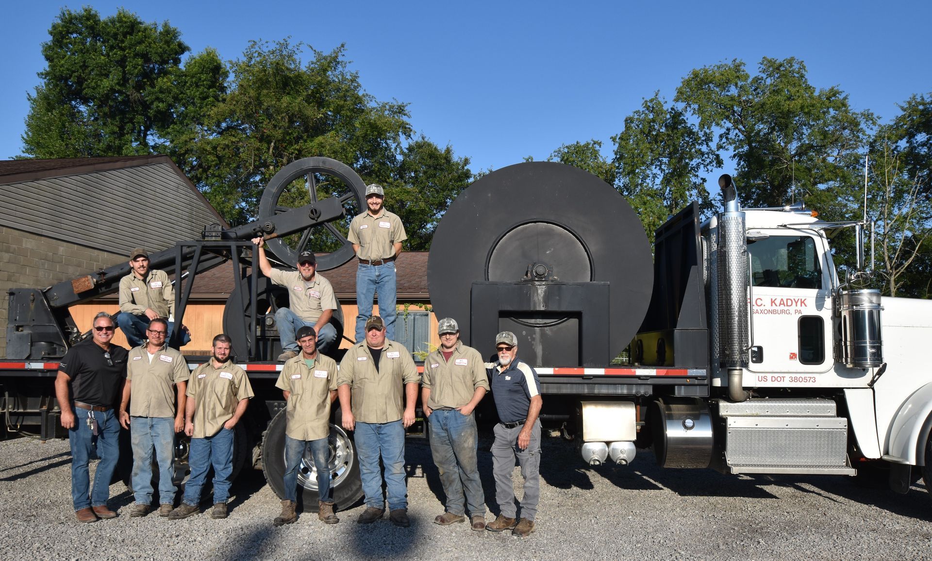 A group of men are posing for a picture in front of a truck.