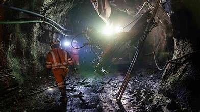 A group of miners are walking through a tunnel in a mine.