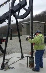 A man in a yellow jacket is working on a machine.
