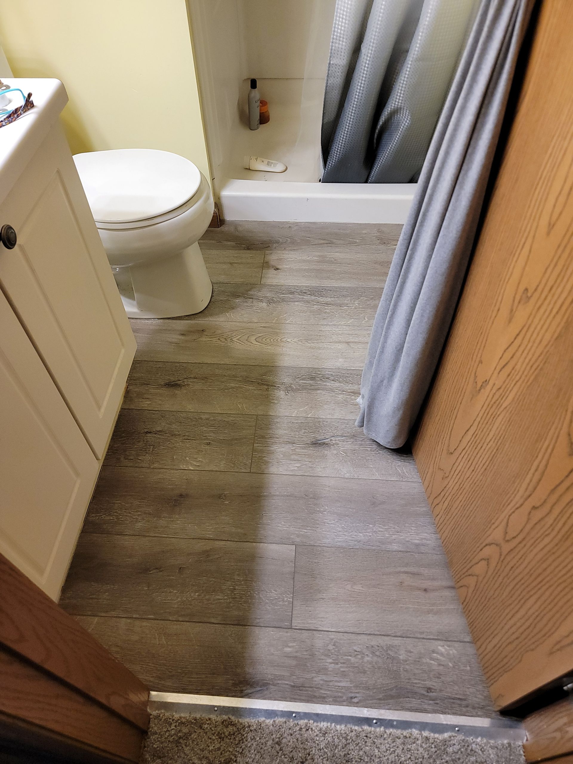 A bathroom with a toilet , sink and shower.