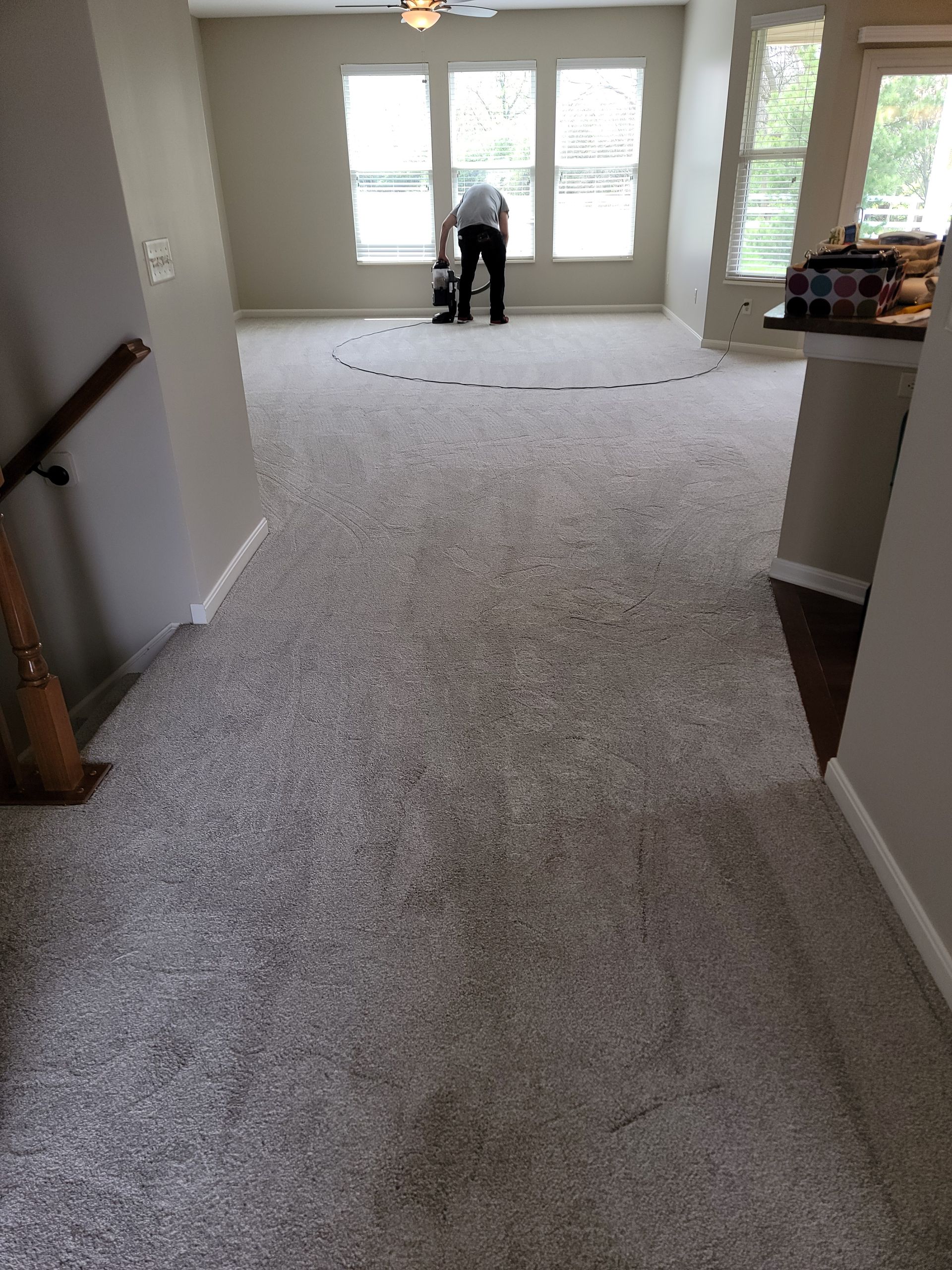 A man is standing on a carpeted floor in a living room.