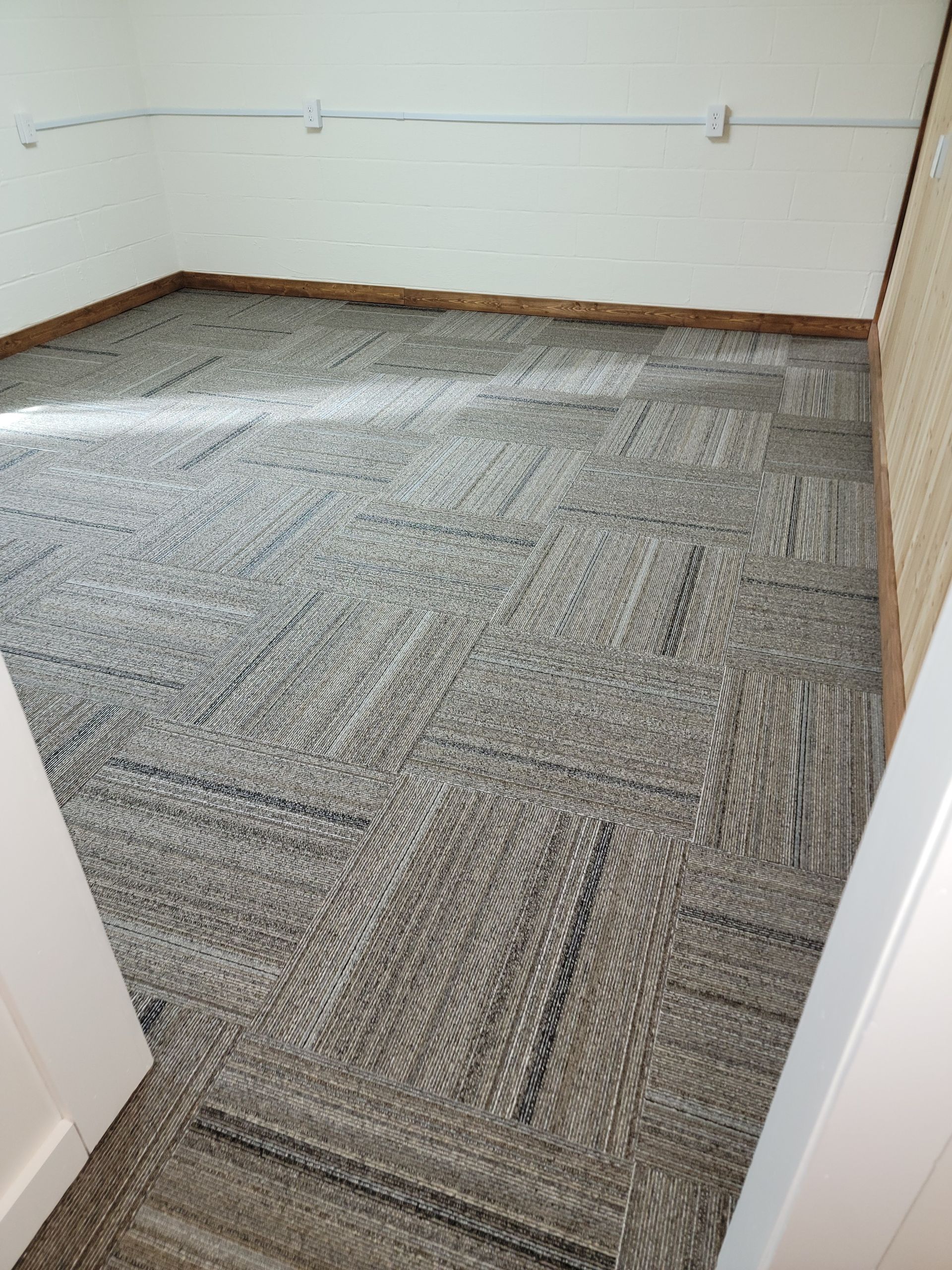 A room with a carpeted floor and a white wall.