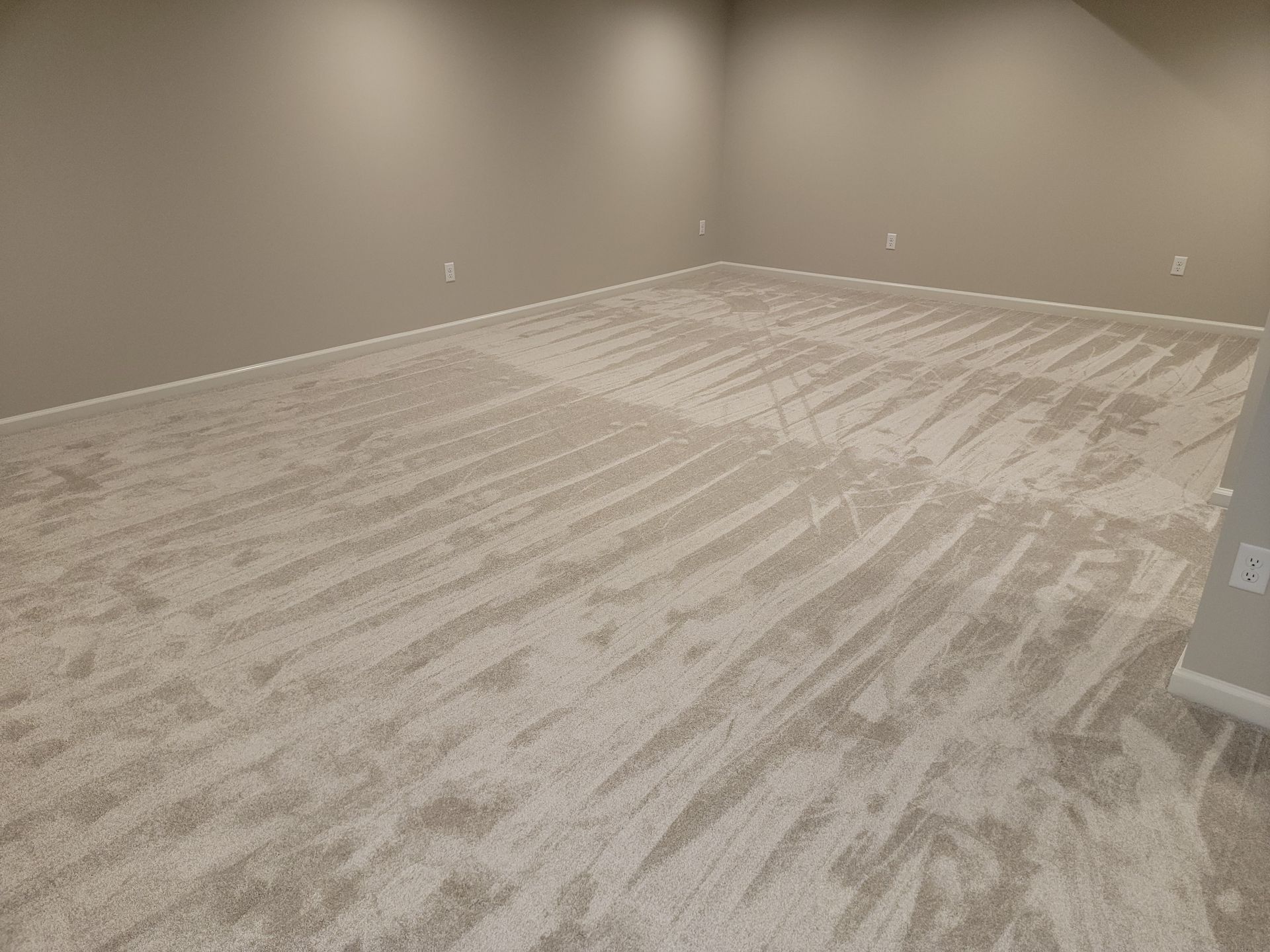 An empty room with a carpeted floor and walls.