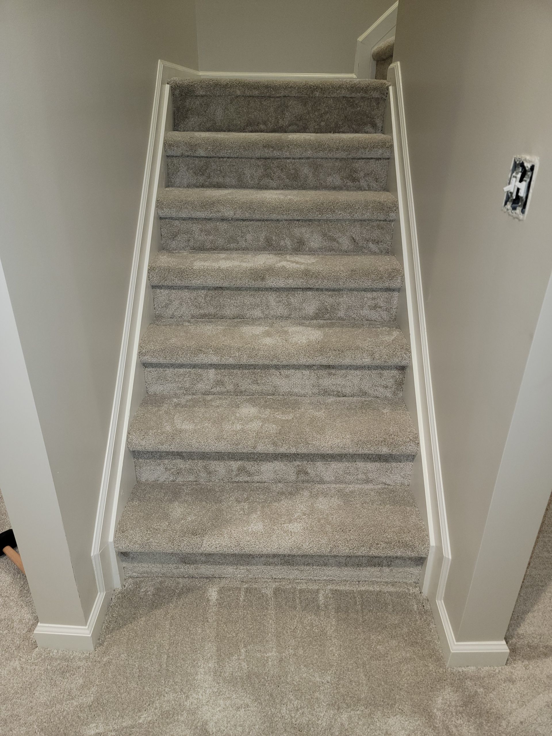 A set of stairs with a carpeted floor in a house.