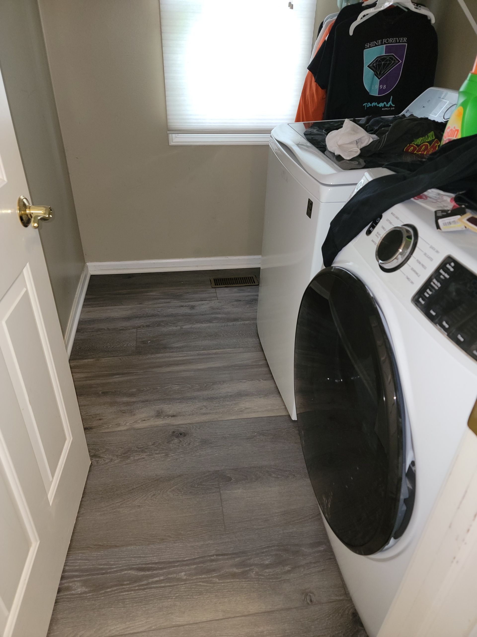 A laundry room with a washer and dryer and a window.