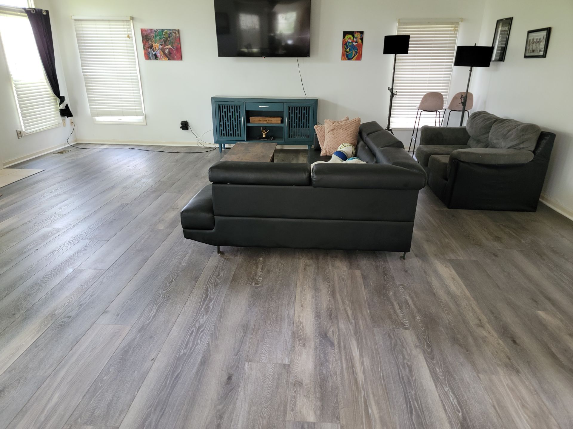 A living room with a couch , chairs , television and fireplace.