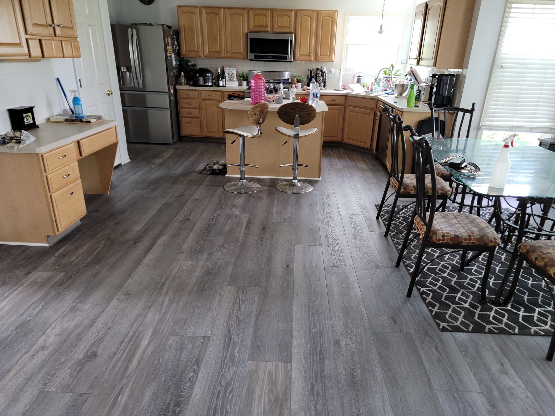 A kitchen with hardwood floors and a dining table and chairs.