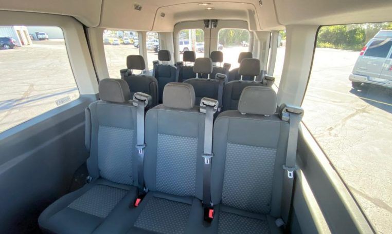 The inside of a van with a lot of seats and a lot of windows.