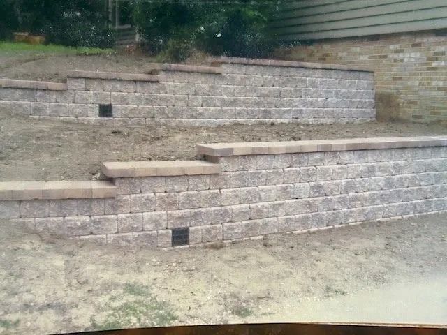 Stone retaining walls built into a sloped yard, creating terraced levels.