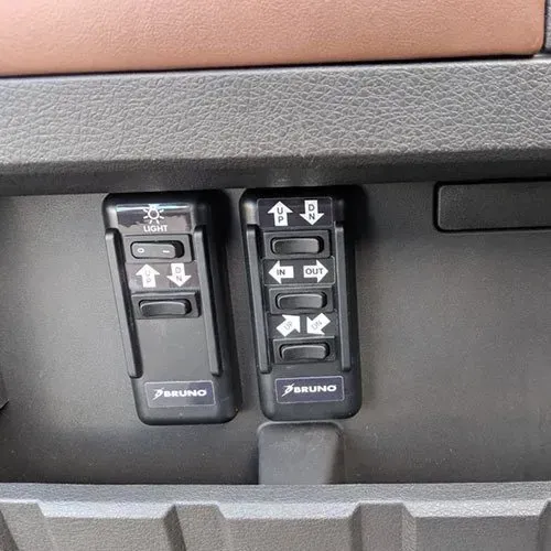 Two black control panels with white symbols. One for lights, the other for mirror adjustments.