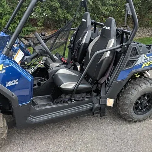 Blue and black off-road vehicle with two seats, a roll cage, and black tires.