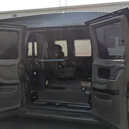 Gray van with open doors, interior visible. Metal bar across the ceiling.