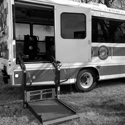 VA Medical vehicle with an accessible ramp extended, parked on grass.