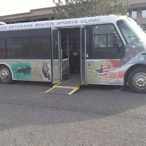 Accessible bus for the Wounded Veterans Winter Sports Clinic, with a ramp extended.