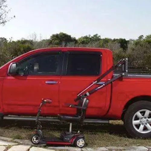 Red pickup truck with a mobility scooter loading lift.