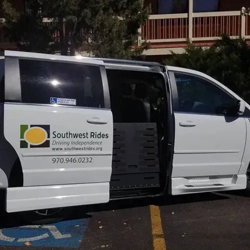 White van with opened side door and wheelchair lift. 