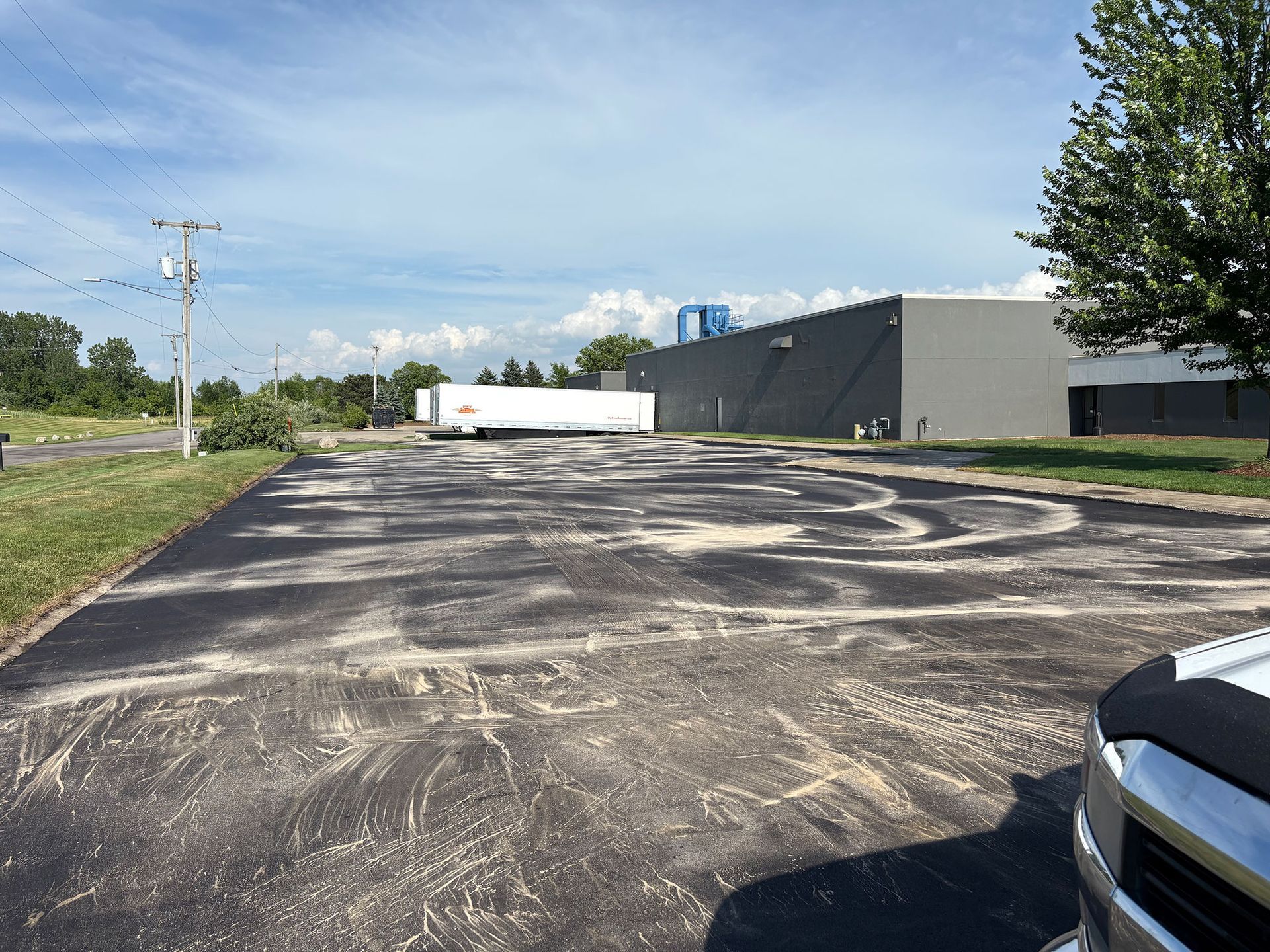 A truck is parked in a parking lot in front of a building.