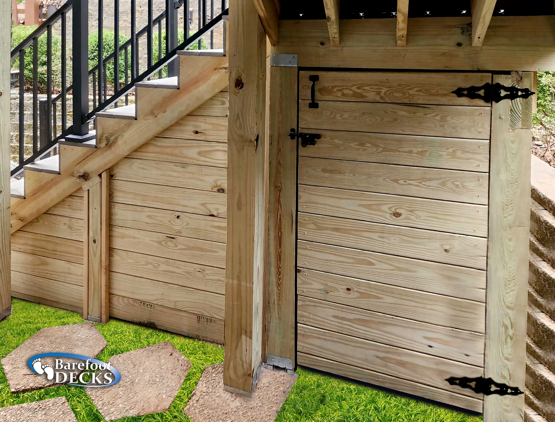Wooden storage door under a deck, with steps and black railing visible.