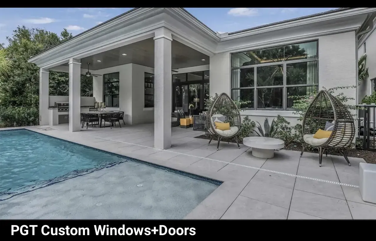 Backyard patio with pool, seating, and custom windows; white columns, neutral colors, and modern design.