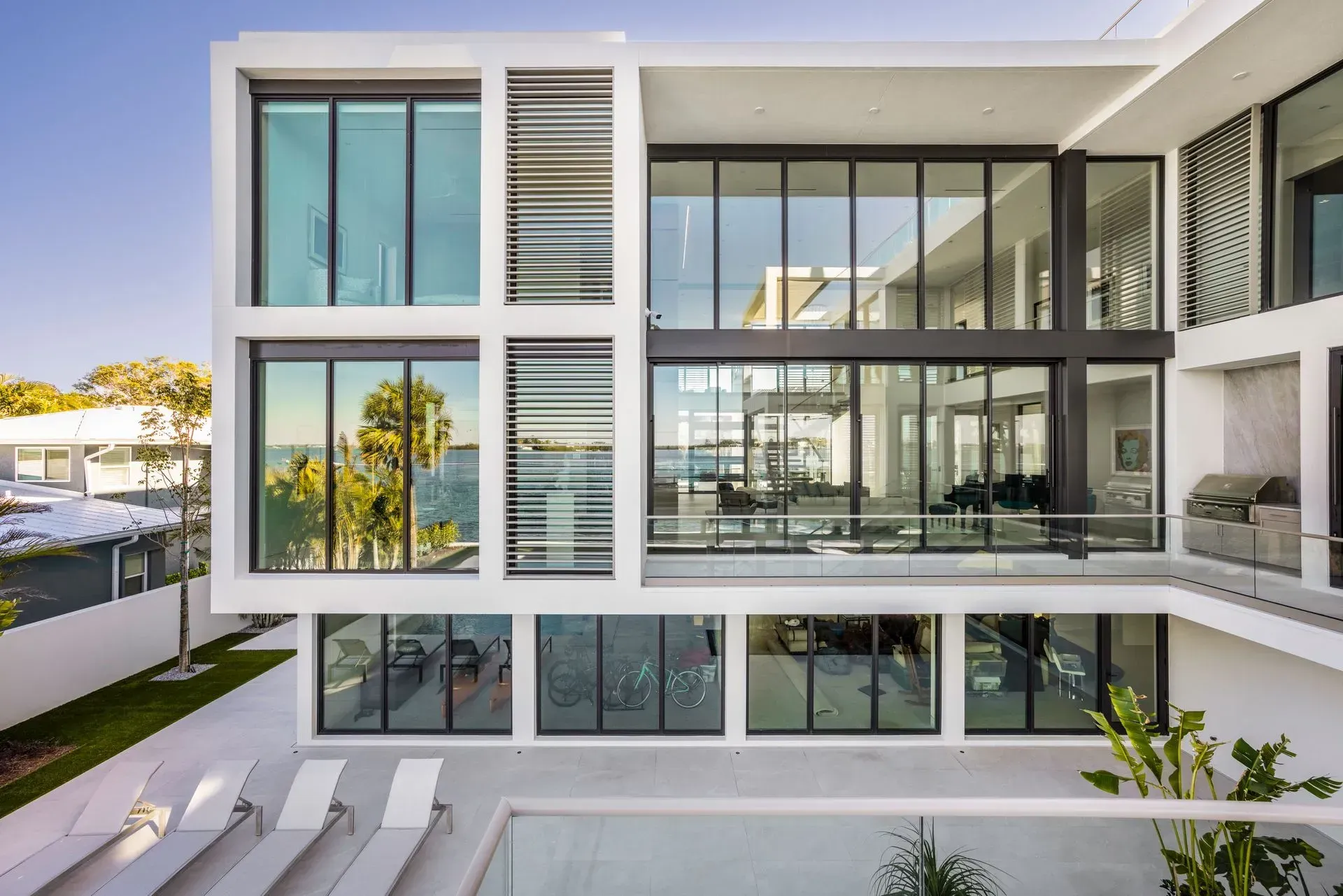 Modern white multi-story house with large windows, exterior view.