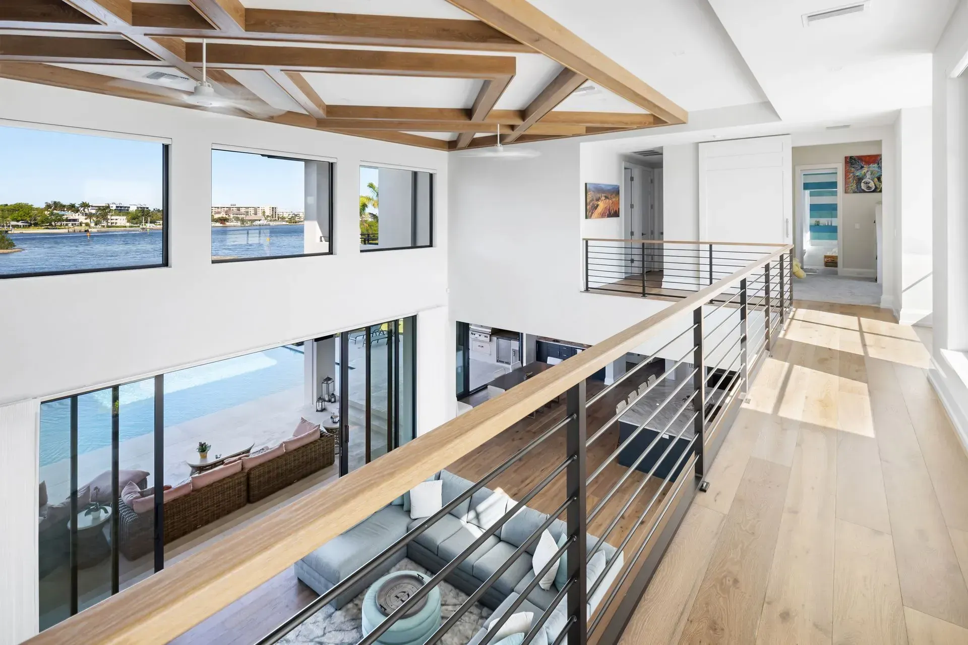 Interior with wood floors, open stairway, and views of water.