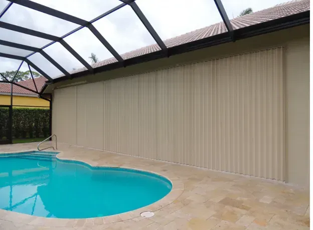 Poolside view with beige vertical sun shades, pool, and glass roof.